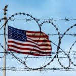 Flag_behind_barbed_wire